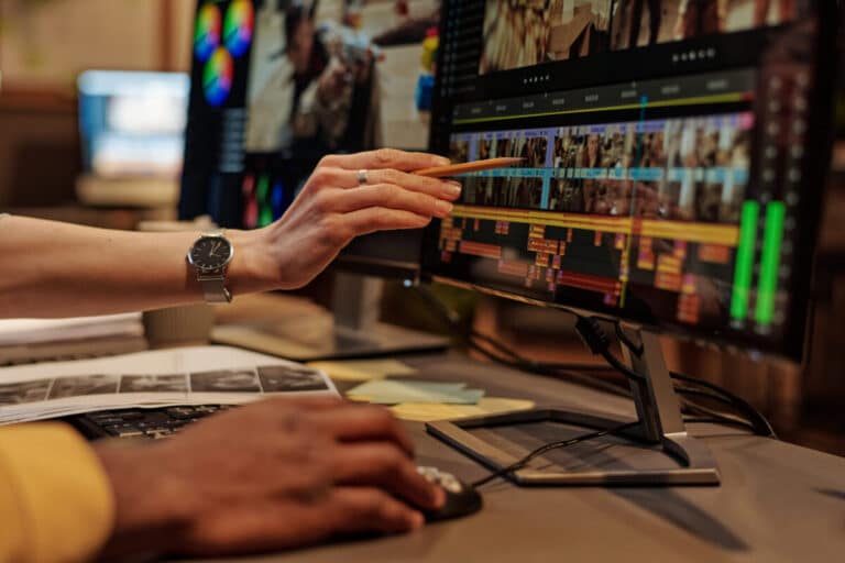 Motion designer travaillant sur la timeline d’un logiciel d’animation, calques et pistes affichés à l’écran