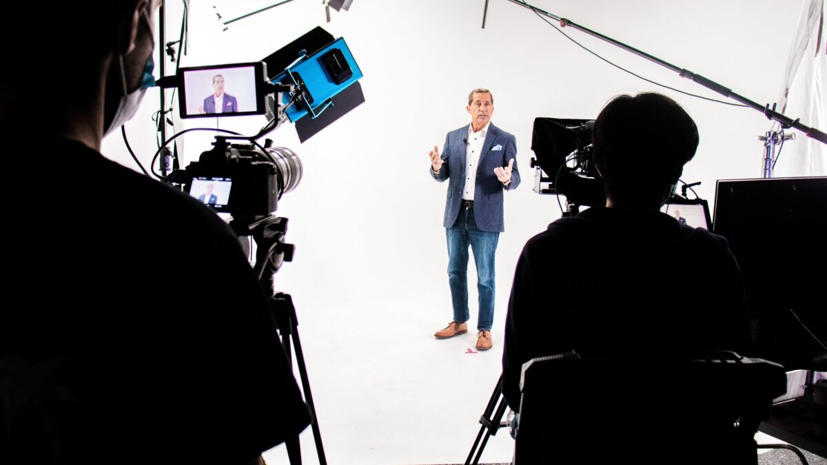Homme filmé en studio par équipe vidéo