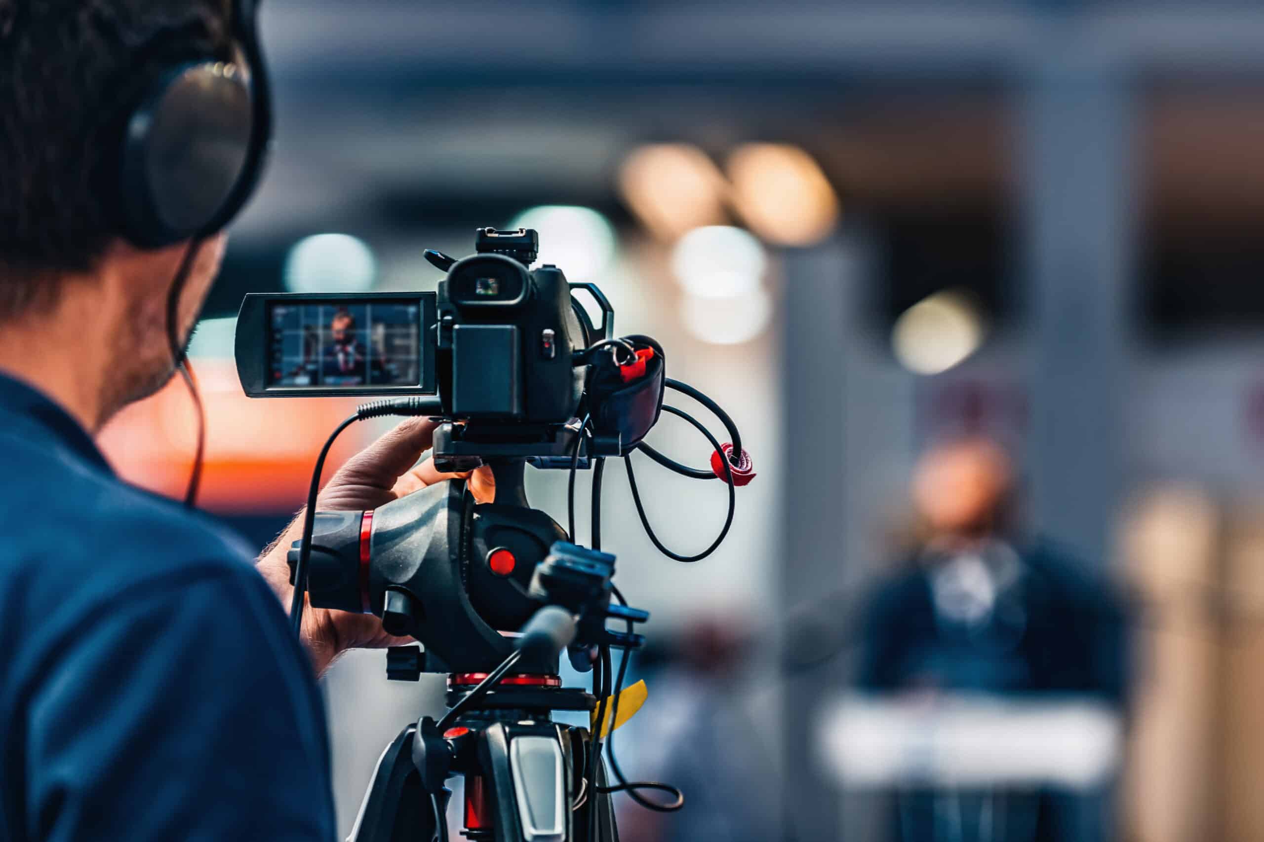 Cameraman filmant un reporter en extérieur