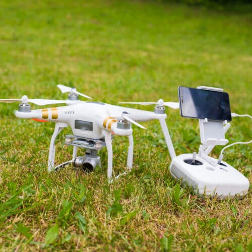 Drone blanc avec télécommande sur pelouse