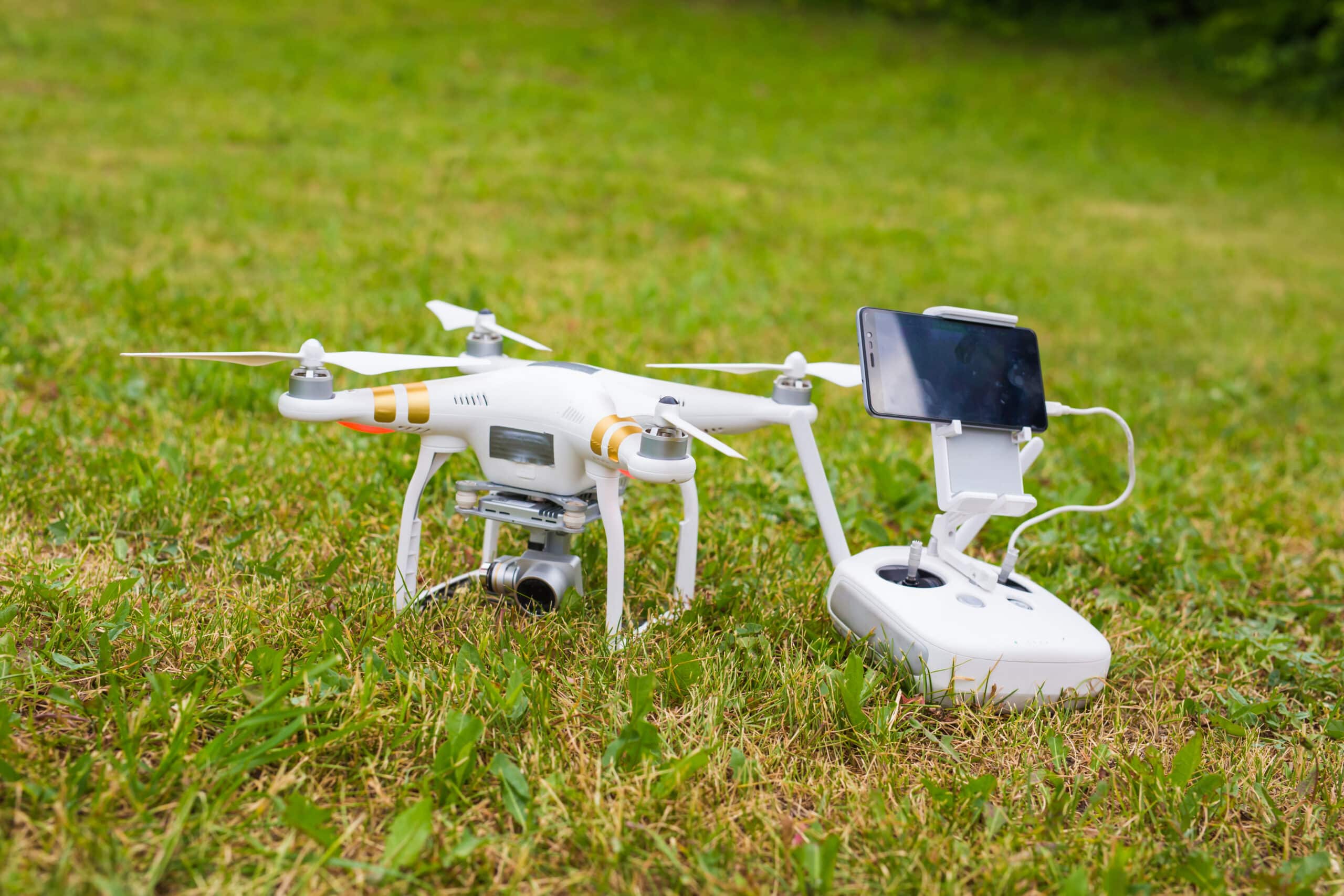 Drone blanc avec télécommande sur pelouse