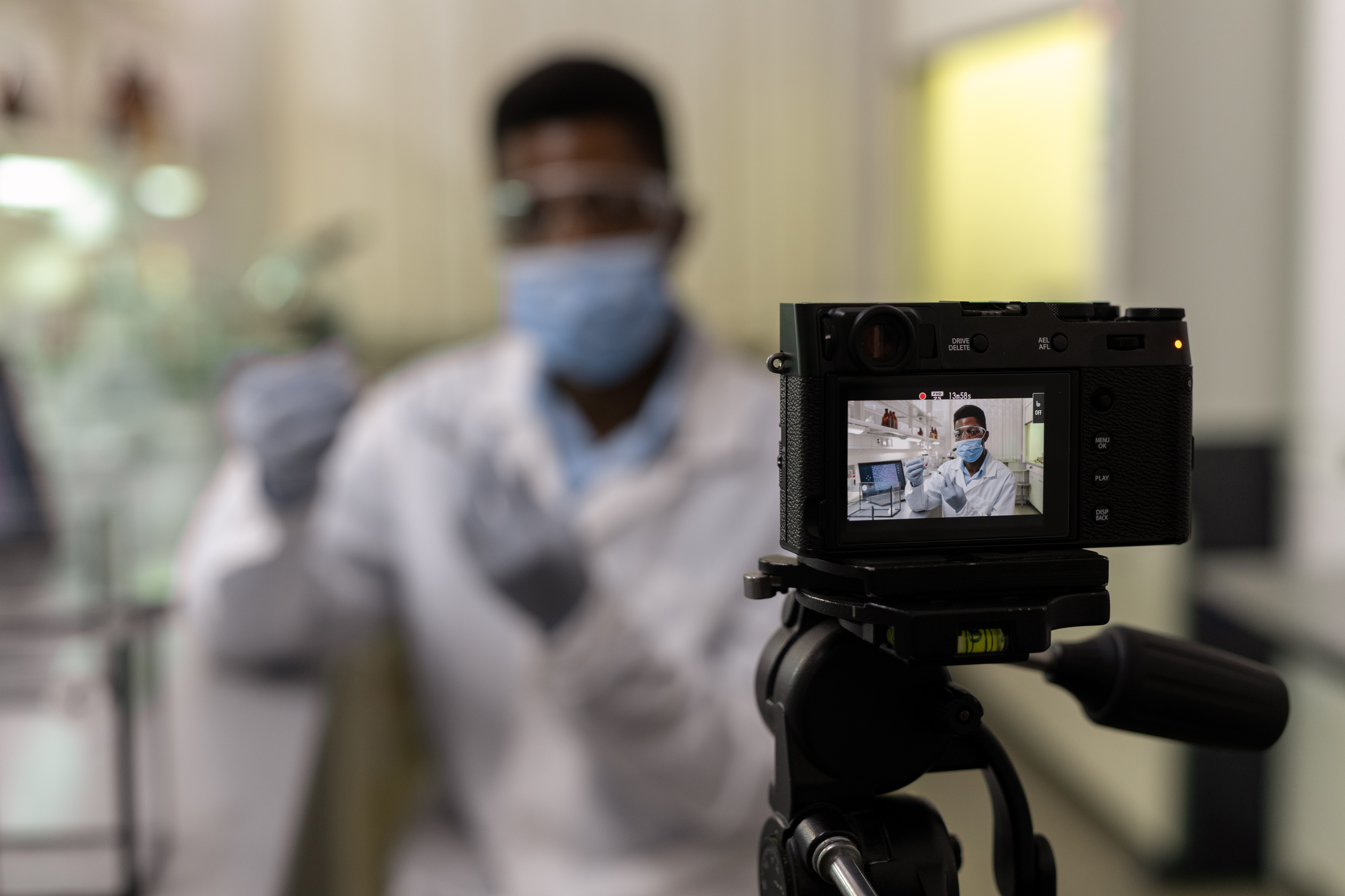 Scientifique filmé en laboratoire devant caméra sur trépied