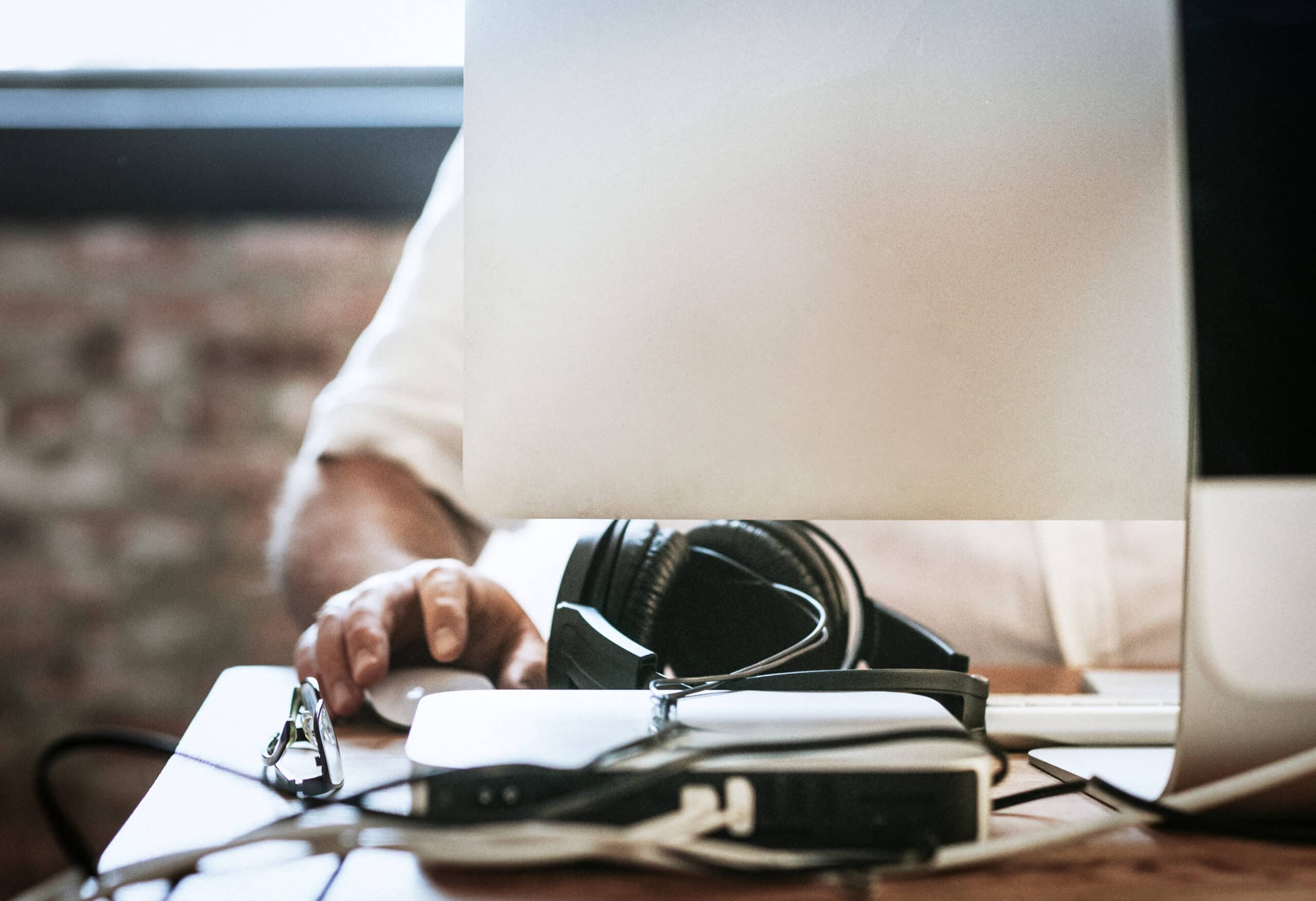 Personne travaillant sur ordinateur avec casque audio