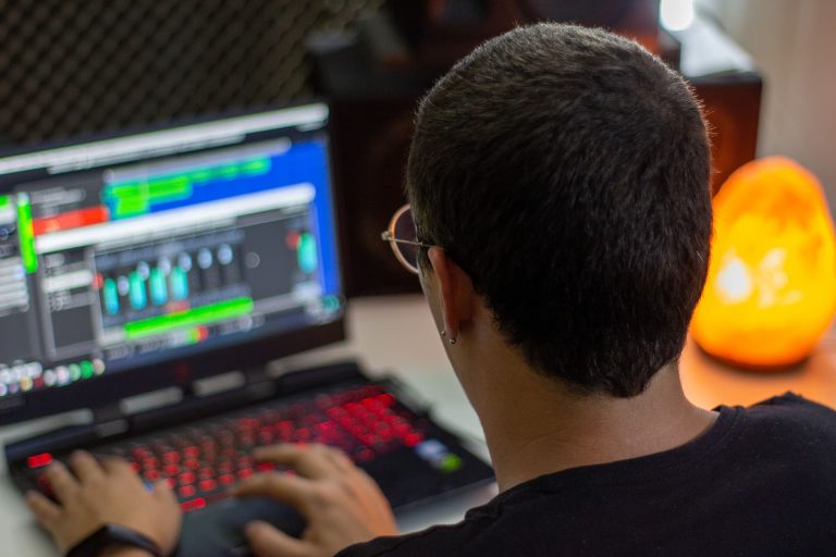Monteur travaillant sur la timeline d’un logiciel de montage, pistes vidéo et audio à l’écran