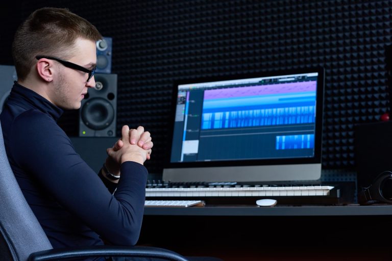 Ingénieur du son vérifiant la forme d’onde d’une voix off sur sa station audio