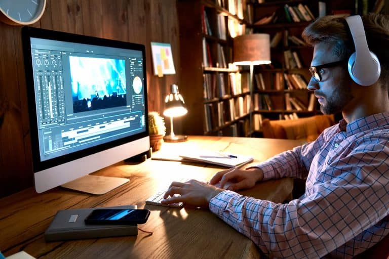 Vidéaste avec casque audio montant une séquence sur un iMac